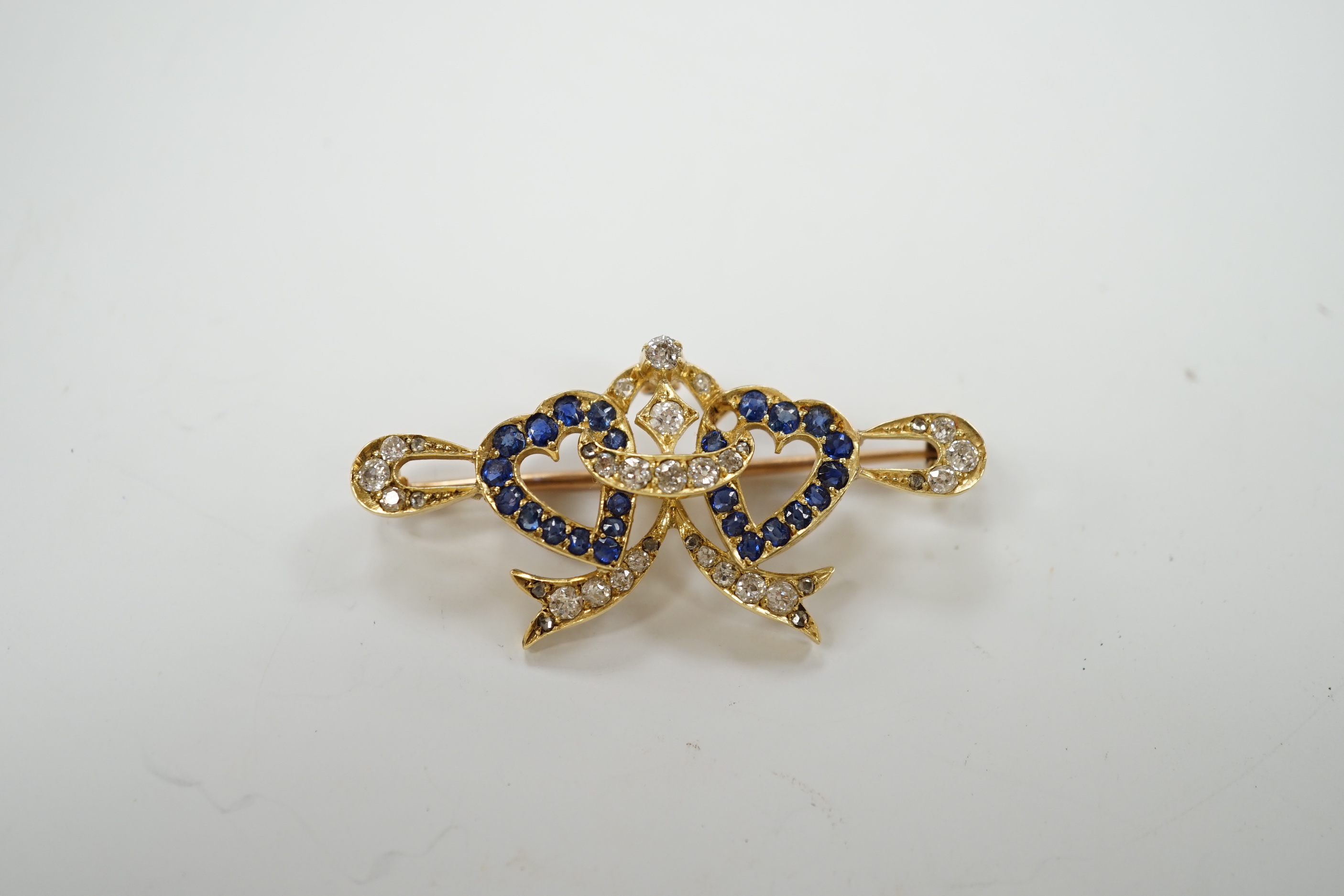 A yellow metal, sapphire and diamond set twin hearts bar brooch, 41mm, gross weight 4.8 grams.